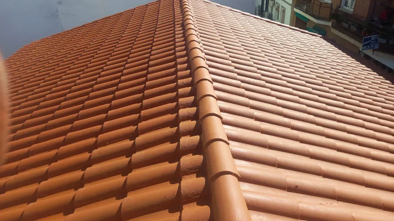 Tejado nuevo de teja mixta color teja con la limatesa terminada, entre edificios